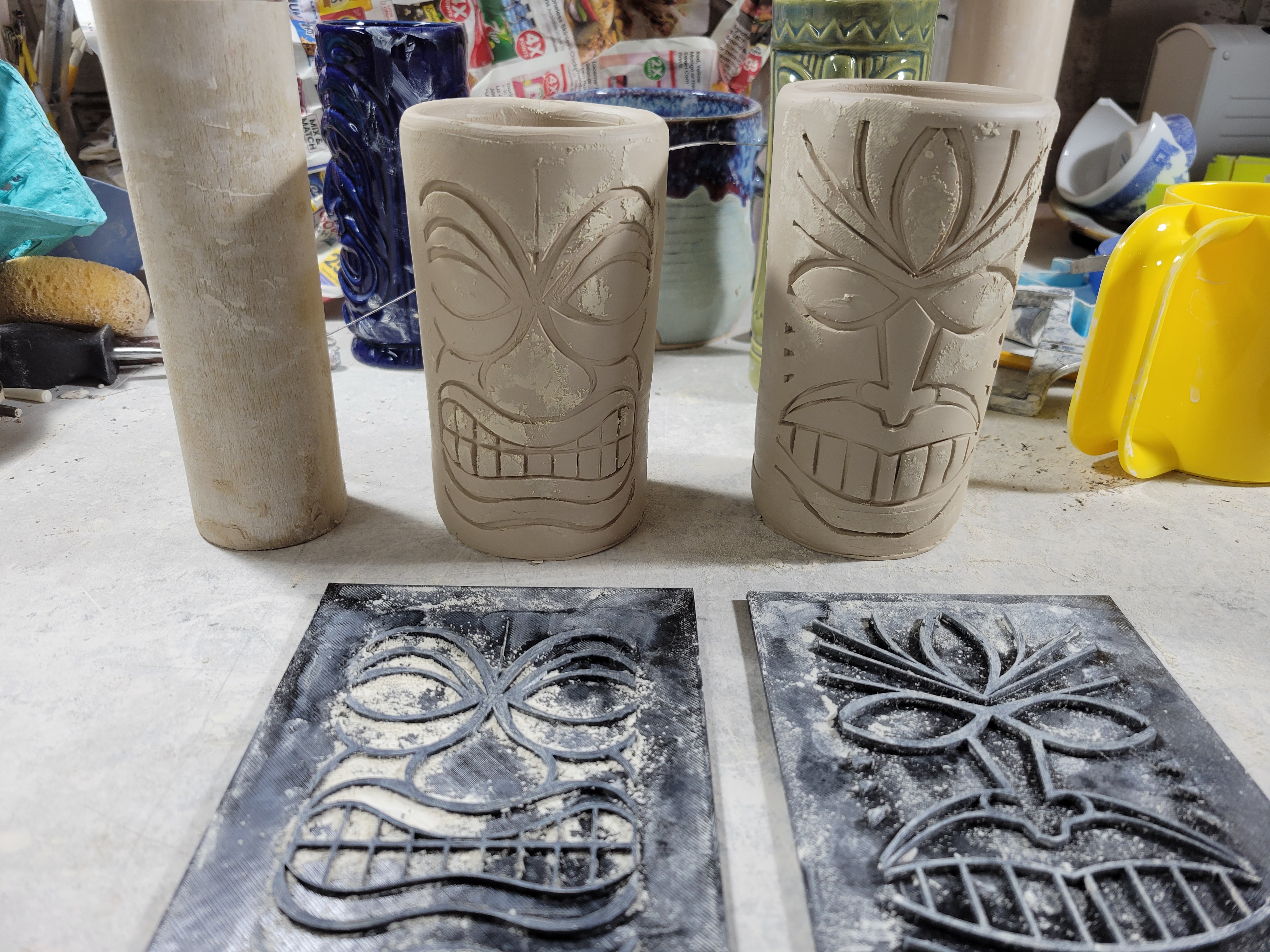 two tiki texture mats with two cups behind them