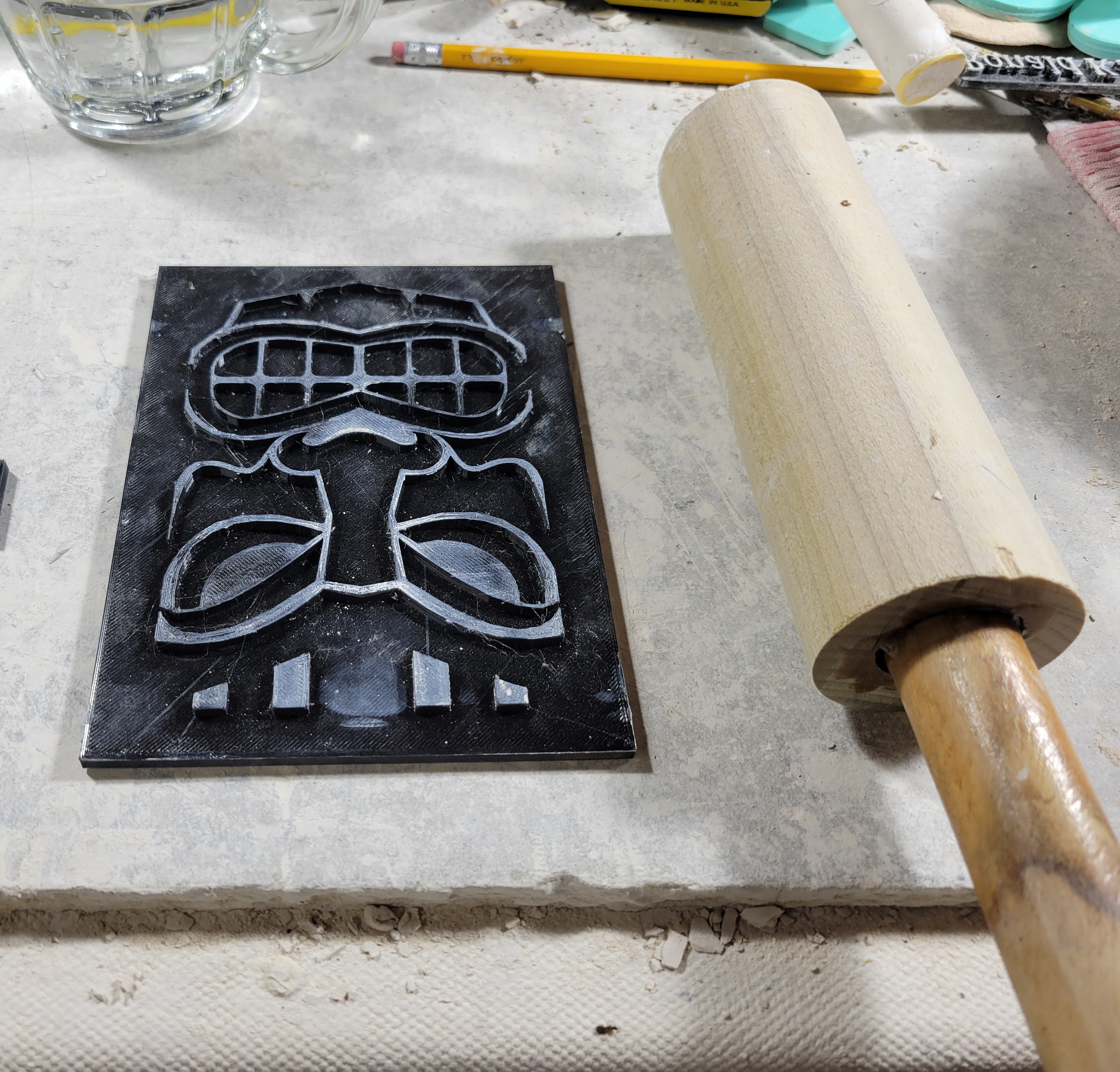 the same texture mat, next to a fat wooden dowel with a handle